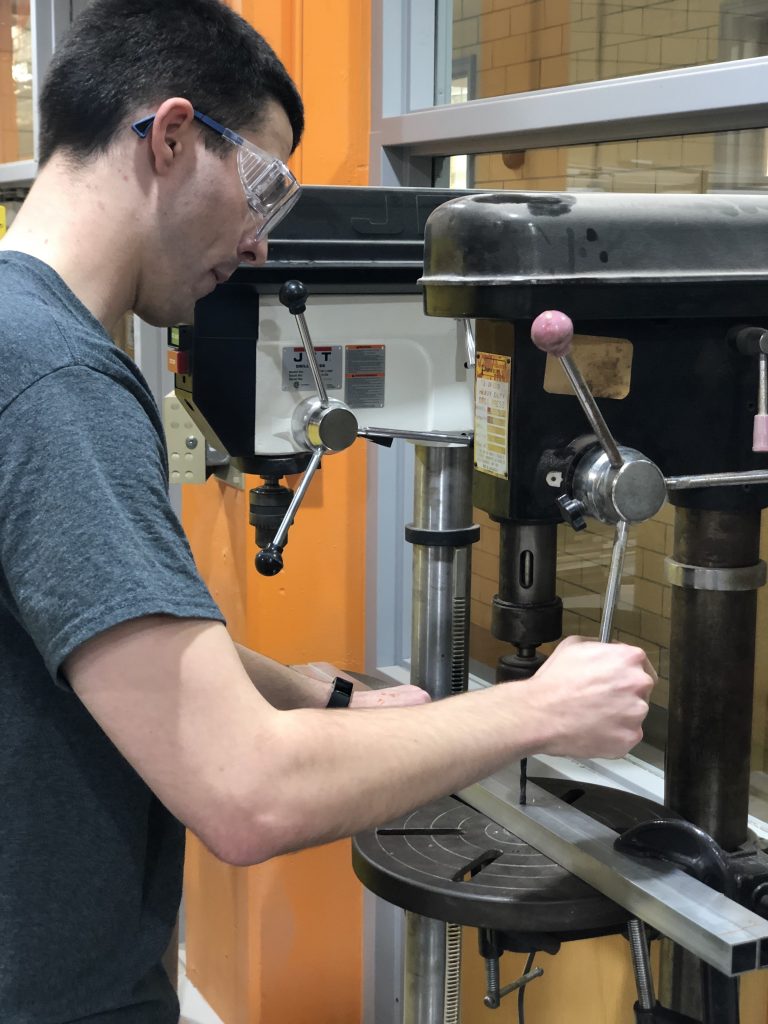 Student uses drill press